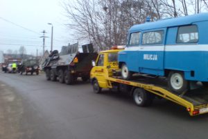 Niebieska furgonetka z tyłu ciężarówki.